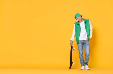 Turuncu arka planda kaykaylı mutlu bir adam. Metin için boşluk