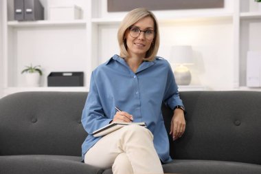 Ofisinde not defteri olan profesyonel psikolog portresi.