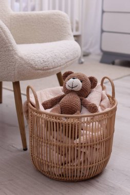Battaniyeli hasır sepet ve içeride oyuncak ayı.