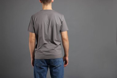Gri arka planda, şık tişörtlü bir adam. Tasarım için model