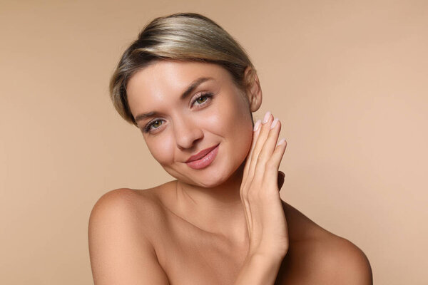 Косметология. Красивая женщина с идеальной кожей на бежевом фоне