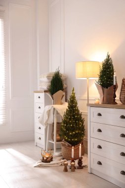 Noel ışıkları ve diğer dekorları olan küçük ladin ağaçları.