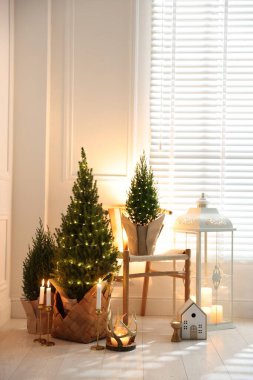 Noel ışıkları ve diğer dekorları olan küçük ladin ağaçları.