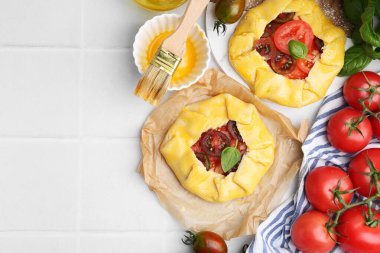 Beyaz fayanslı masada domates ve fesleğenli çiğ galetler. Metin için boşluk