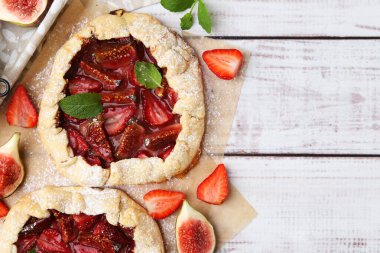 Çilekli lezzetli galetler, incir ve nane şekerli ahşap masa, düz yatak. Metin için boşluk