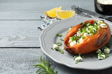 Lezzetli pişmiş patates, beyaz peynirli ve yeşil soğanlı, yakın plan, ahşap masa. Metin için boşluk