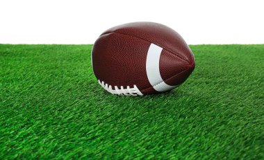 Amerikan futbol topu yeşil çimlerin üzerinde beyaz arka plana karşı. Spor malzemeleri.