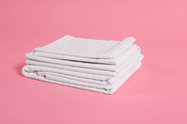 Pembe arka planda temiz çarşaf yığını