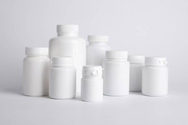 Beyaz arka planda birçok plastik tıbbi şişe