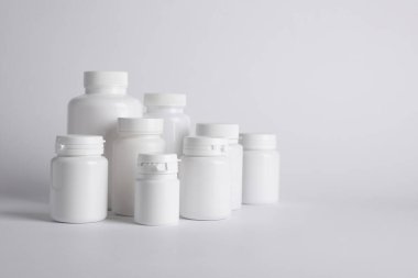 Beyaz arka planda birçok plastik tıbbi şişe, metin için boşluk