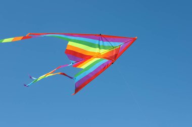 Mavi gökyüzünde uçan renkli bir uçurtma