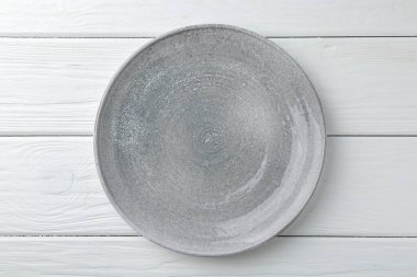 Beyaz ahşap masada şık bir tabak, üst manzara.