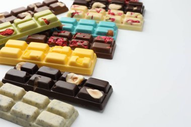Beyaz arka planda farklı lezzetli çikolatalar, yakın plan. Metin için boşluk