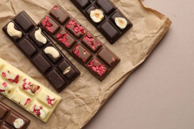 Bej arka planda farklı lezzetli çikolatalar, üst manzara. Metin için boşluk