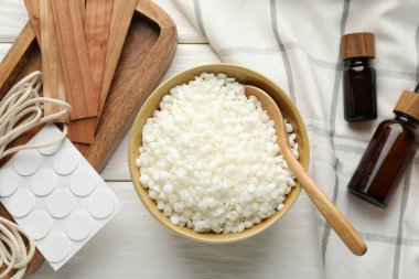 El yapımı mumlar yapıyorum. Kasedeki soya cilası, filizler, temel yağlar, beyaz ahşap masa üzerindeki yapışkan ve sicim, düz uzanmış.