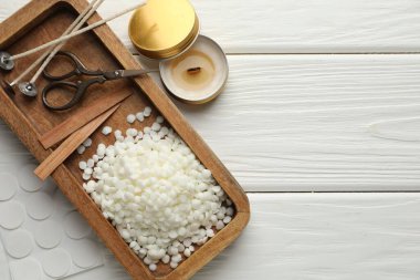 Soya mumu, fitil, çıkartma, makas ve mum beyaz ahşap masa, düz yatış. Metin için boşluk