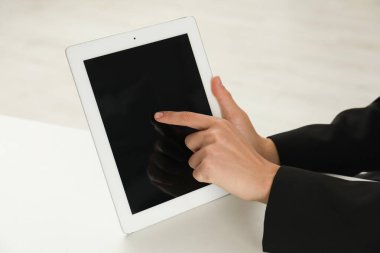 Beyaz masada tablet kullanan bir iş kadını, yakın plan. Modern teknoloji