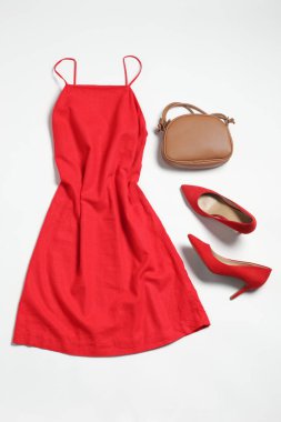 Beyaz arka planda çantalı şık kıyafetler, düz yatış.