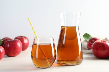 Taze elma suyu ve beyaz ahşap masada meyveler