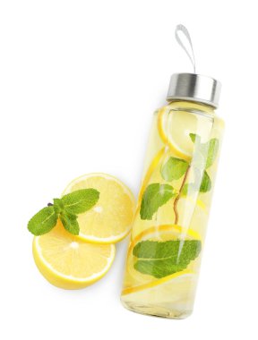 Şişe içinde naneli limon suyu, taze meyve ve yapraklar beyaza izole edilmiş, üst manzara