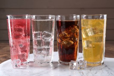 Farklı aromalı soda ve bardaklarda buz küpleri.