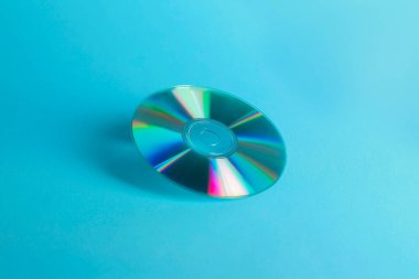 One shiny compact disc on light blue background clipart