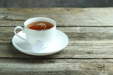 Tahta masada sıcak içecekle birlikte çay poşeti. Metin için boşluk