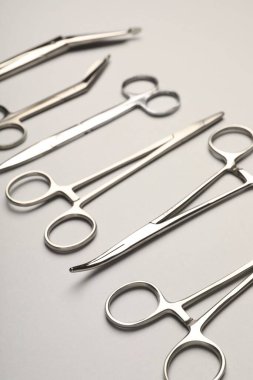 Gri arka planda farklı cerrahi araçlar, yakın plan