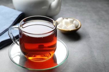Gri masadaki fincanda siyah çay, yakın plan. Metin için boşluk
