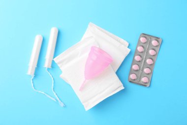 Açık mavi arkaplanda adet ürünleri ile düz kompozisyon