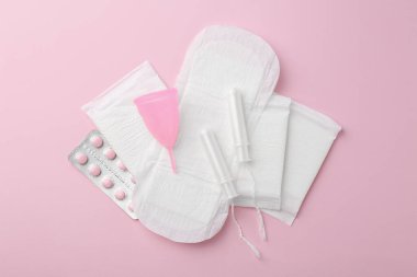 Pembe arka planda adet ürünleri olan düz kompozisyon