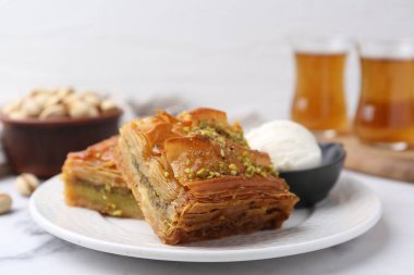 Beyaz mermer masada ezilmiş fındıklı ve dondurmalı enfes baklava, yakın plan.