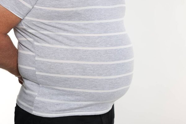 Overweight man in tight t-shirt on white background, closeup