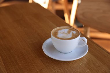 Kafedeki ahşap masada bir fincan aromatik kahve, yakın plan. Metin için boşluk