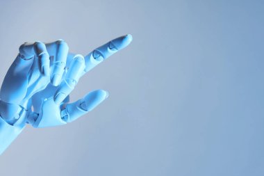 Yapay zeka. Robot el açık mavi arkaplanda bir şeye işaret ediyor, metin için boşluk