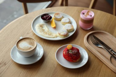 Lezzetli süzme peynirli krep, tatlı ve kahve Cafe 'deki ahşap masada servis edilir.