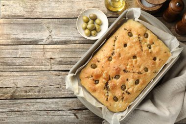 Zeytinli, kekikli, ahşap masadaki baharatlı, nefis Focaccia ekmeği. Metin için boşluk