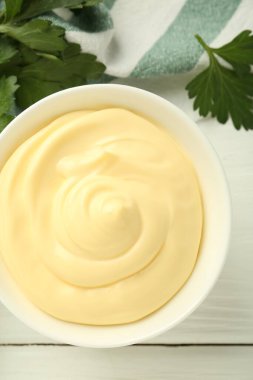 Kasede mayonez sosu ve beyaz ahşap masada maydanoz.