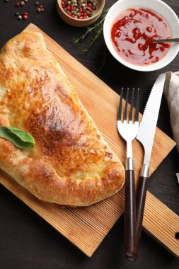 Tahta masada servis edilen leziz taze calzone pizzası.