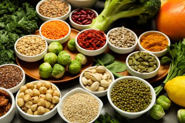 Süper yemek. Gri masada farklı sağlıklı gıda ürünleri var.