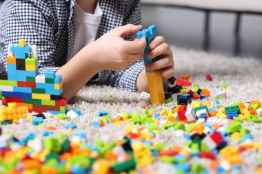 Şirin çocuk evdeki yapı taşlarıyla oynuyor, yakın plan.