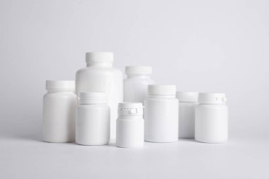 Beyaz arka planda birçok plastik tıbbi şişe