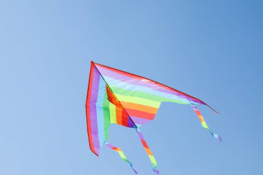 Mavi gökyüzünde uçan renkli bir uçurtma