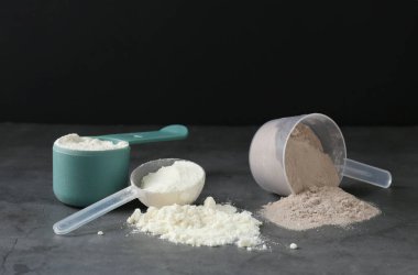 Gri desenli masa üzerindeki kepçe kepçelerinde protein tozları