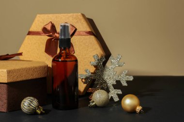 Kozmetik ürünler, hediye kutuları ve Noel dekoru koyu bej arka planda, metin için boşluk