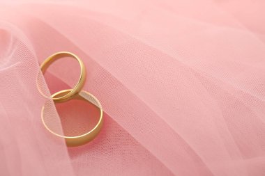 Pembe kumaş üzerinde güzel altın alyanslar, metin için yer