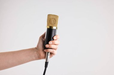 Gri arka planda mikrofonu olan kadın, yakın plan. Metin için boşluk