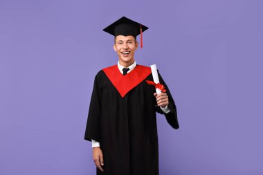 Mezuniyetten sonra mor arka planda diplomalı mutlu bir öğrenci.