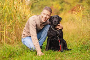 Gülümseyen adam ve sevimli köpek sonbahar günü açık havada