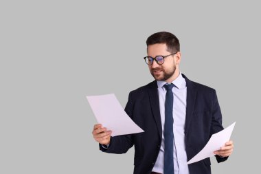Gri arkaplan üzerine belgeleri olan bankacının portresi, metin için boşluk